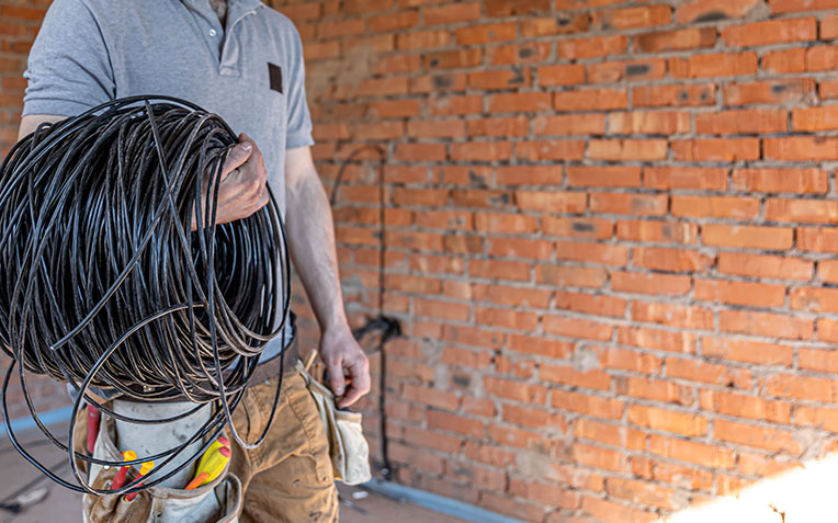 Experienced electrician inspecting electrical panel in home improvement project.