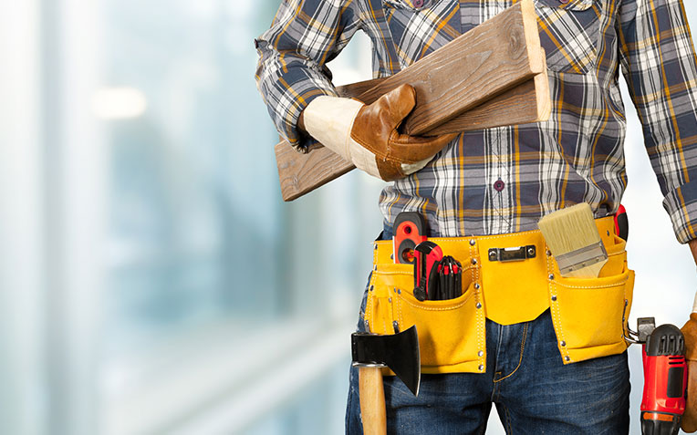 A construction worker operating heavy machinery at a Global Home Improvements construction site.