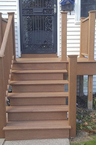 Wooden deck with stairs, railing, and potted plants - Global Home Improvements deck building services.