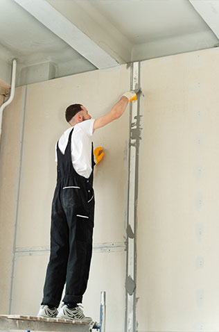 A closeup view of drywall panels being installed during a home improvement project.